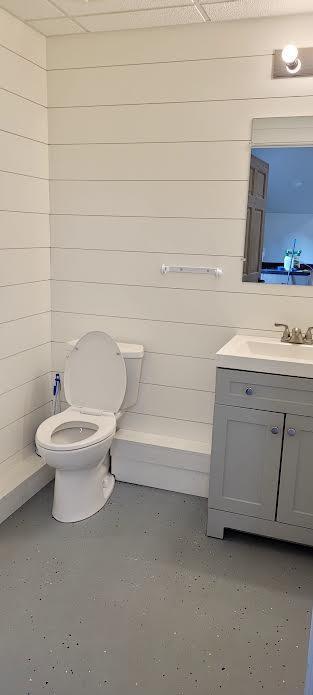 9029 Crown Hill Ct, Brainerd, MN 56401 - bathroom featuring vanity, concrete flooring, and wooden walls