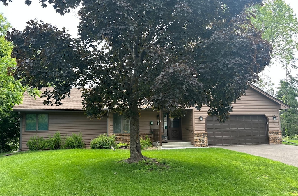 241 Bayberry Avenue Ct, Stillwater, MN 55082 - obstructed view of property with a garage, a front lawn, asphalt driveway, and brick siding