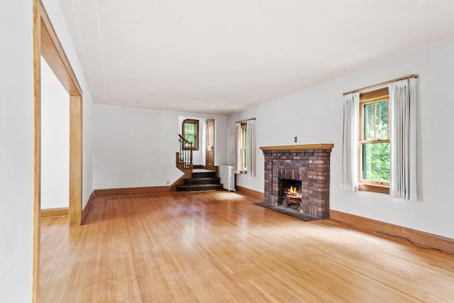 4300 Beard Ave S, Minneapolis, MN 55410 - unfurnished living room with wood-type flooring, a brick fireplace, and stairway