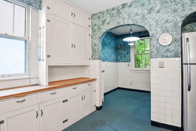 4300 Beard Ave S, Minneapolis, MN 55410 - kitchen featuring wallpapered walls, wooden counters, white cabinets, a wainscoted wall, and dark colored carpet