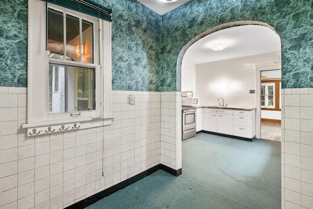 4300 Beard Ave S, Minneapolis, MN 55410 - bathroom with wallpapered walls, tile walls, wainscoting, and vanity