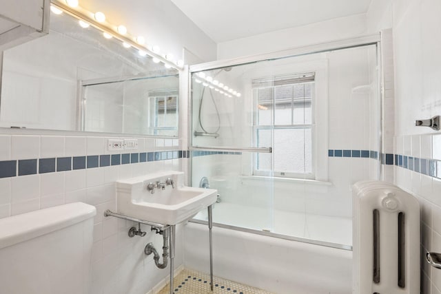 4300 Beard Ave S, Minneapolis, MN 55410 - full bath featuring radiator, tile walls, and bath / shower combo with glass door