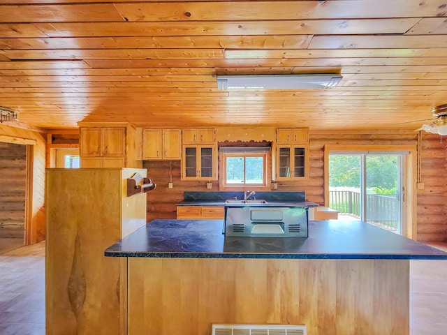 1283 Island Lake Dr NW, Powers Twp, MN 56435 - kitchen featuring wooden ceiling, log walls, plenty of natural light, dark countertops, and glass insert cabinets
