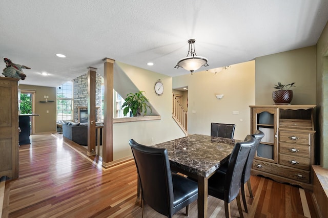 13591 347th St, Chisago Lake Twp, MN 55045 - dining space featuring wood finished floors, stairs, recessed lighting, a textured ceiling, and a fireplace