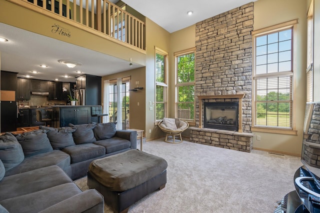 13591 347th St, Chisago Lake Twp, MN 55045 - living area with a stone fireplace, light carpet, a towering ceiling, and recessed lighting