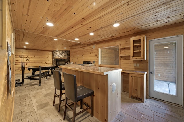 13591 347th St, Chisago Lake Twp, MN 55045 - kitchen with wood walls, recessed lighting, a kitchen island, light countertops, and a kitchen bar
