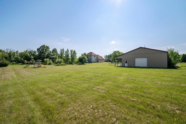 13591 347th St, Chisago Lake Twp, MN 55045 - view of grassy yard with a garage, a playground, and an outdoor structure