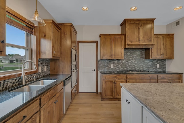 1504 20th Ave S, Sartell, MN 56377 - kitchen featuring stainless steel appliances, brown cabinetry, light wood-style floors, dark stone countertops, and recessed lighting