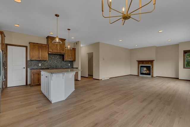 1504 20th Ave S, Sartell, MN 56377 - kitchen with a kitchen island, brown cabinets, light wood finished floors, open floor plan, and backsplash