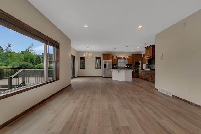1504 20th Ave S, Sartell, MN 56377 - unfurnished living room featuring a chandelier, light wood-type flooring, and recessed lighting