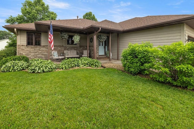 1008 3rd St NE, New Prague, MN 56071 - view of front of property with a front lawn, a shingled roof, brick siding, and a porch