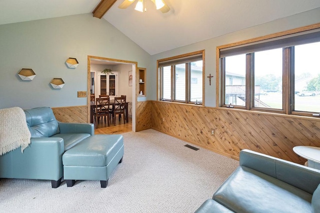 1008 3rd St NE, New Prague, MN 56071 - carpeted living area featuring wood walls, a wainscoted wall, and a ceiling fan