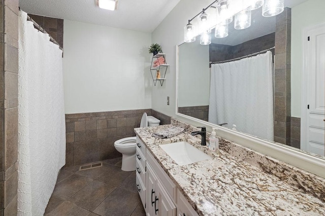 1008 3rd St NE, New Prague, MN 56071 - bathroom featuring vanity, tile walls, tile patterned flooring, wainscoting, and a shower with shower curtain