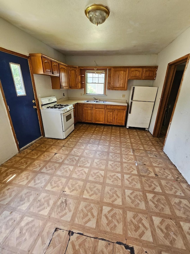 730 Front St, Albert Lea, MN 56007 - kitchen with white appliances, light countertops, brown cabinets, and a textured ceiling