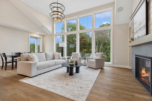 2706 Lakeview Ct, Little Canada, MN 55117 - living room featuring a high ceiling, a tile fireplace, plenty of natural light, a chandelier, and wood finished floors