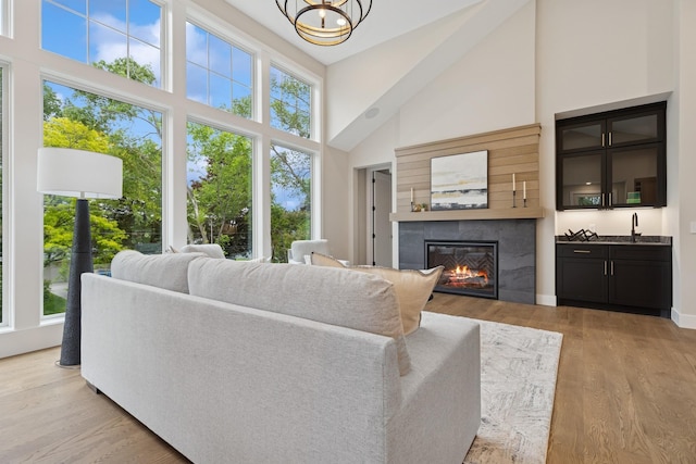 2706 Lakeview Ct, Little Canada, MN 55117 - living room with a high ceiling, a glass covered fireplace, light wood-style floors, and a chandelier