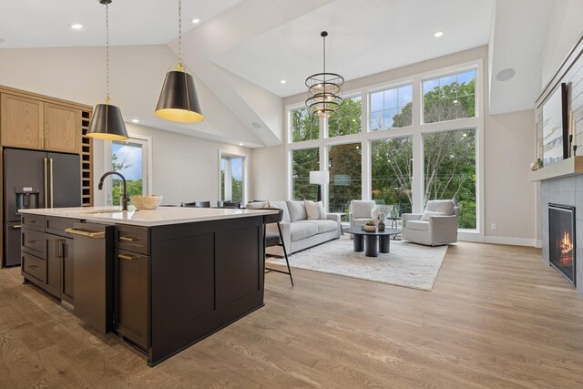2706 Lakeview Ct, Little Canada, MN 55117 - kitchen with high vaulted ceiling, appliances with stainless steel finishes, light countertops, a tiled fireplace, and open floor plan