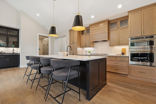 2706 Lakeview Ct, Little Canada, MN 55117 - kitchen with stainless steel double oven, custom range hood, backsplash, a kitchen breakfast bar, and light wood finished floors