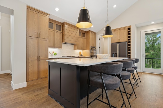 2706 Lakeview Ct, Little Canada, MN 55117 - kitchen featuring stainless steel refrigerator with ice dispenser, black electric cooktop, decorative backsplash, a breakfast bar, and light wood-style flooring