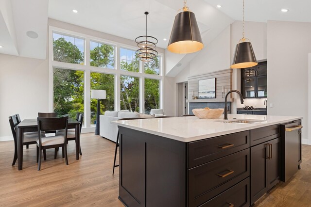 2706 Lakeview Ct, Little Canada, MN 55117 - kitchen with high vaulted ceiling, light countertops, an island with sink, light wood finished floors, and pendant lighting