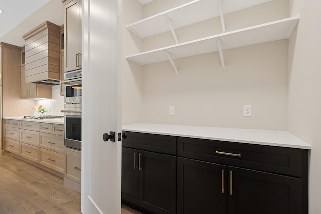 2706 Lakeview Ct, Little Canada, MN 55117 - kitchen featuring open shelves, light wood-style flooring, tasteful backsplash, dark cabinetry, and stainless steel appliances