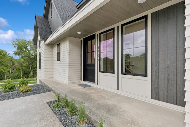 2706 Lakeview Ct, Little Canada, MN 55117 - property entrance with a shingled roof, a porch, and board and batten siding