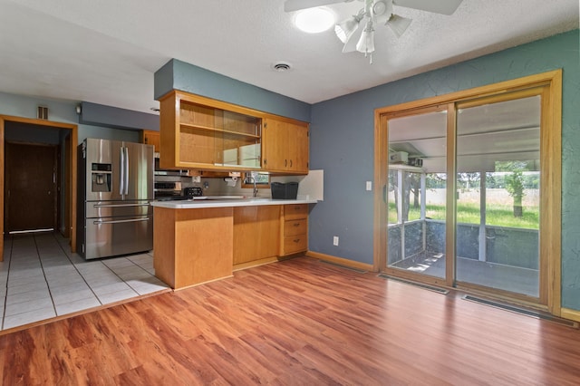 39743 County Road 1, Brockway Twp, MN 56367 - kitchen with stainless steel fridge, light wood finished floors, a peninsula, a ceiling fan, and light countertops