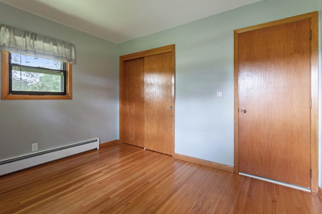 39743 County Road 1, Brockway Twp, MN 56367 - unfurnished bedroom with wood finished floors, a closet, and a baseboard heating unit