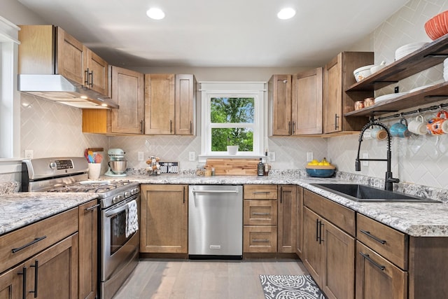 3178 253rd Ave NW, Isanti, MN 55040 - kitchen featuring stainless steel appliances, under cabinet range hood, light wood-style flooring, open shelves, and tasteful backsplash