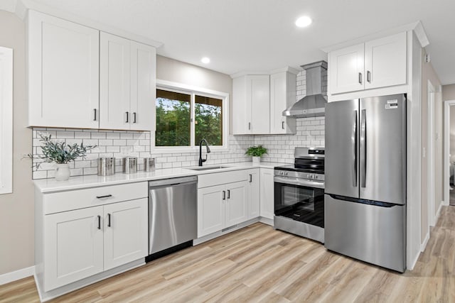 6980 Crest Dr, Maple Grove, MN 55311 - kitchen with appliances with stainless steel finishes, wall chimney exhaust hood, light countertops, light wood-style floors, and white cabinets