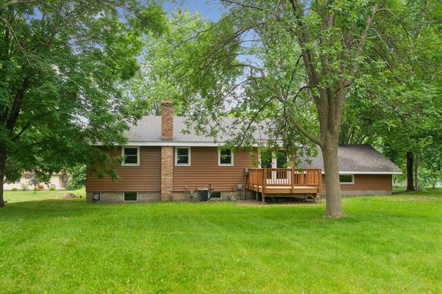 711 9th St NW, Buffalo, MN 55313 - rear view of house featuring a deck, a yard, and a chimney