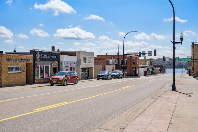711 9th St NW, Buffalo, MN 55313 - view of asphalt road featuring sidewalks, curbs, street lighting, and traffic lights