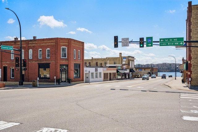 711 9th St NW, Buffalo, MN 55313 - view of asphalt road featuring street lights, sidewalks, traffic lights, and curbs