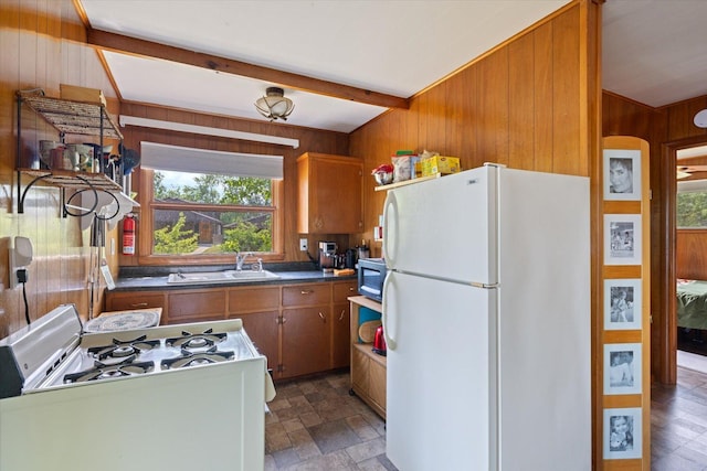 2236 Birch Point Rd Unit A, Tower, MN 55790 - kitchen with white appliances, wooden walls, brown cabinets, dark countertops, and beam ceiling