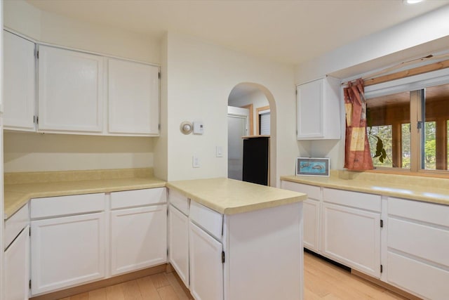 2236 Birch Point Rd Unit A, Tower, MN 55790 - kitchen with white cabinetry, a peninsula, light wood-style floors, arched walkways, and light countertops