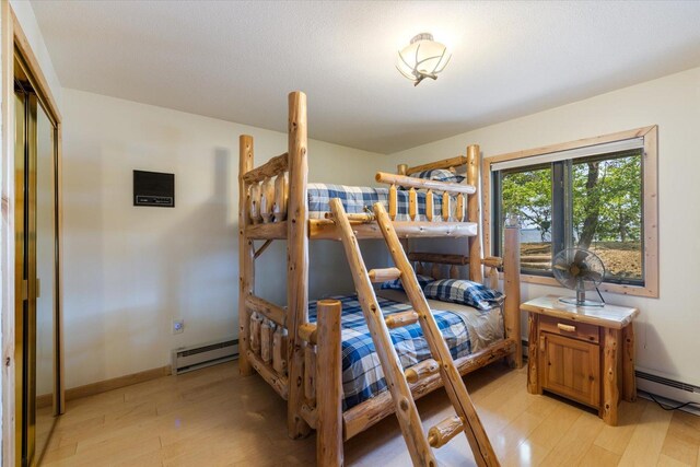 2236 Birch Point Rd Unit A, Tower, MN 55790 - bedroom with a baseboard radiator and light wood-style flooring