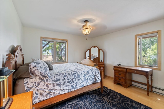 2236 Birch Point Rd Unit A, Tower, MN 55790 - bedroom featuring multiple windows, light wood finished floors, and a baseboard radiator