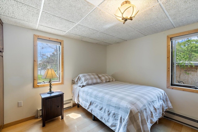 2236 Birch Point Rd Unit A, Tower, MN 55790 - bedroom featuring a baseboard radiator, multiple windows, baseboard heating, and a paneled ceiling