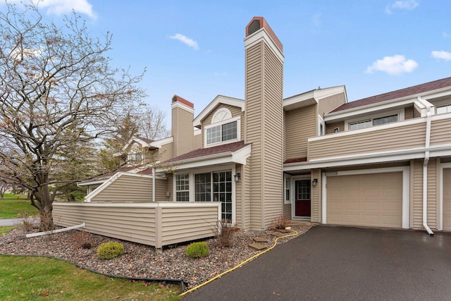 2060 Shenandoah Ct Unit F, Plymouth, MN 55447 - view of front of home featuring a chimney, a balcony, and asphalt driveway