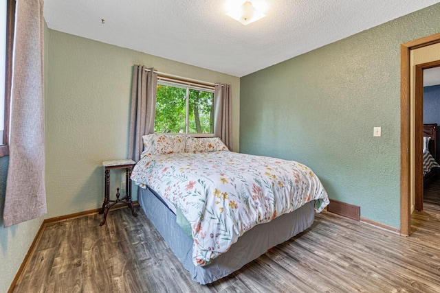 2115 3rd Ave NE, Owatonna, MN 55060 - bedroom featuring a textured wall, wood finished floors, and a textured ceiling