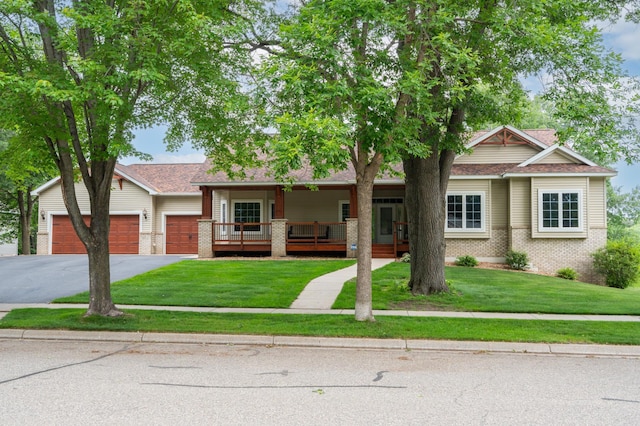1805 Maple Ln, Saint Cloud, MN 56304 - view of front of property featuring a porch, asphalt driveway, brick siding, a front lawn, and an attached garage