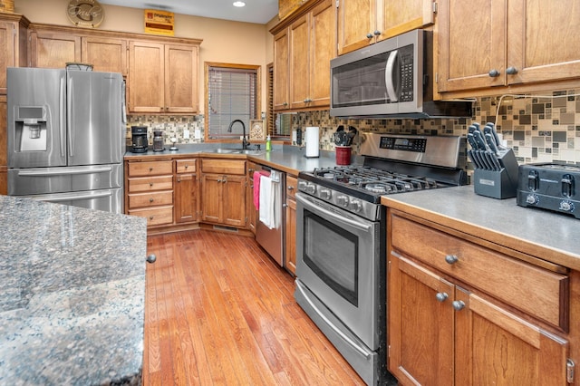 1805 Maple Ln, Saint Cloud, MN 56304 - kitchen featuring appliances with stainless steel finishes, backsplash, recessed lighting, brown cabinetry, and light wood-style flooring