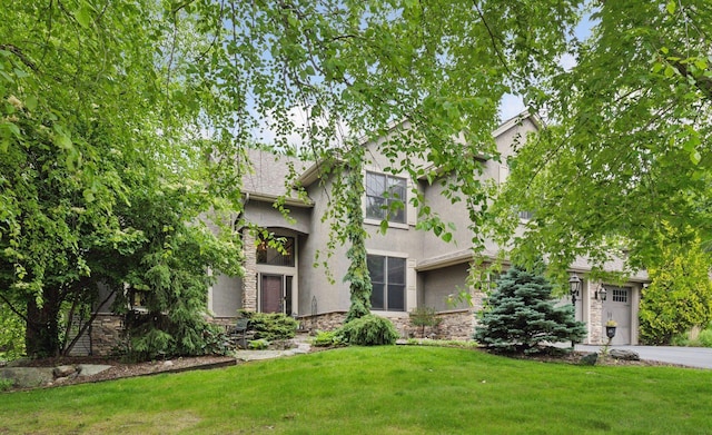 7216 Gunflint Trl, Chanhassen, MN 55317 - tudor house with stone siding, a front yard, stucco siding, and driveway
