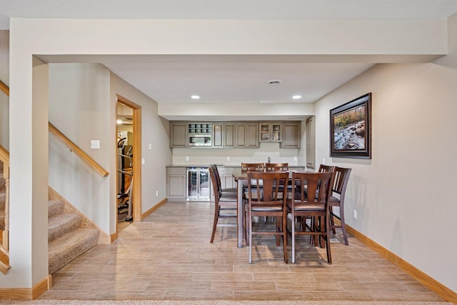 9015 Schutte Ct, Corcoran, MN 55340 - dining space with wet bar, stairs, light wood-style floors, wine cooler, and recessed lighting