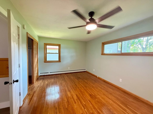 17535 Riverwood Dr, Little Falls, MN 56345 - unfurnished bedroom featuring baseboard heating, wood finished floors, a closet, and a ceiling fan