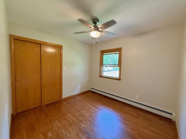 17535 Riverwood Dr, Little Falls, MN 56345 - unfurnished bedroom with baseboard heating, wood finished floors, a closet, and ceiling fan