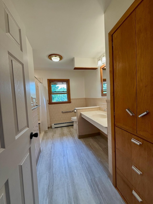 17535 Riverwood Dr, Little Falls, MN 56345 - full bath featuring a baseboard heating unit, tile walls, vanity, wainscoting, and a shower with shower curtain