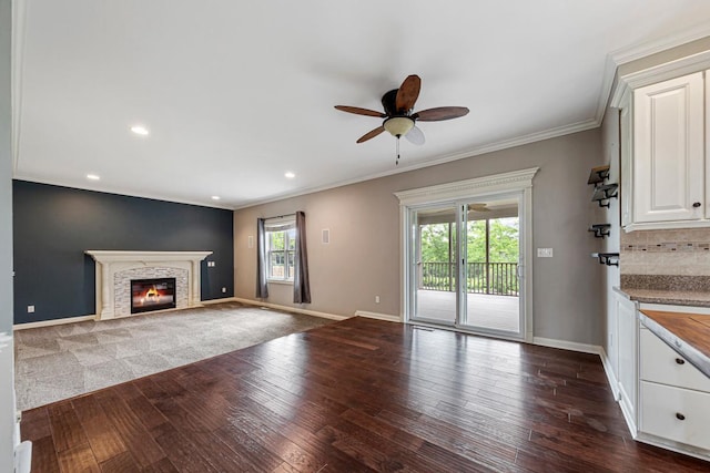 1830 Whitetail Run Pl NE, Owatonna, MN 55060 - unfurnished living room with dark wood-type flooring, ceiling fan, ornamental molding, a glass covered fireplace, and recessed lighting