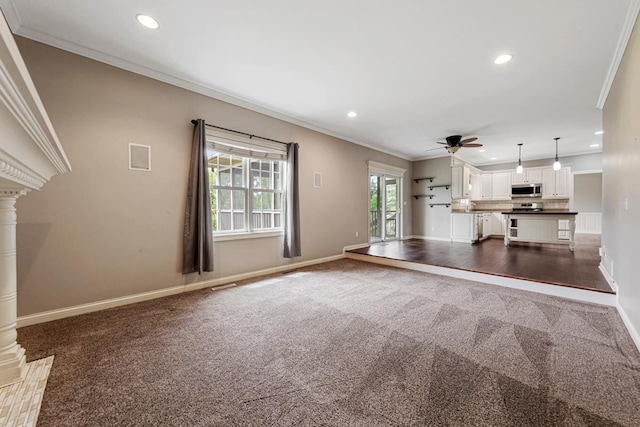 1830 Whitetail Run Pl NE, Owatonna, MN 55060 - unfurnished living room with carpet flooring, crown molding, a ceiling fan, decorative columns, and recessed lighting