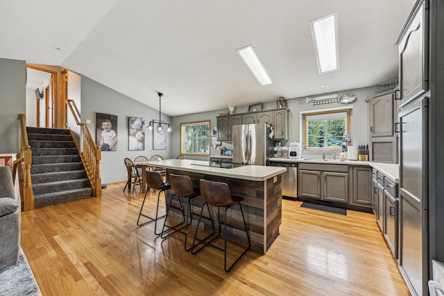 620 Acacia Dr S, Annandale, MN 55302 - kitchen featuring appliances with stainless steel finishes, light wood-type flooring, light countertops, plenty of natural light, and vaulted ceiling